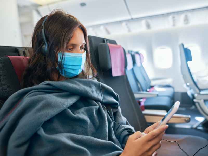 Women wearing a mask on an airplane to stay helathy